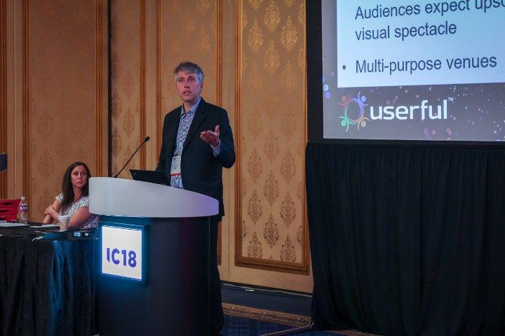 تيم غريفين ، كبير مسؤولي التكنولوجيا في Userful ، يقدم عرضا تقديميا حول AV-over-IP في Infocomm 2018 ، مع Marielle Crisanti من Matrix Video Communications في الخلفية