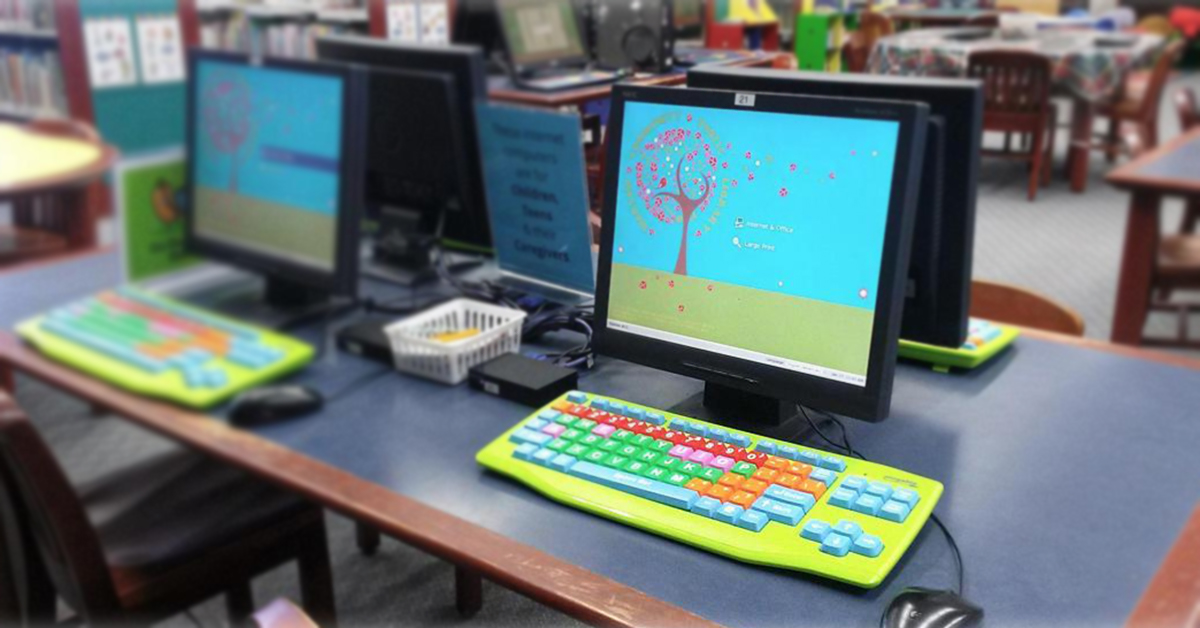 جدول في مكتبة مجتمع وارسو العامة مع أجهزة كمبيوتر تستخدم سطح مكتب المستخدم ولوحات المفاتيح الملونة